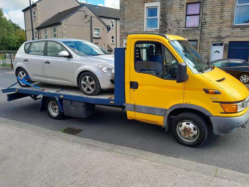 Scrap car loaded on a recovery truck for collection in Kendal